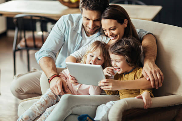 A family browses a tablet together while they look at their IdentityIQ dashboard. We offer family identity theft protection to keep your family safe.