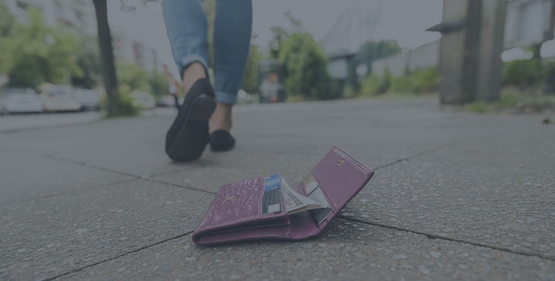 A wallet on the ground and person walking away