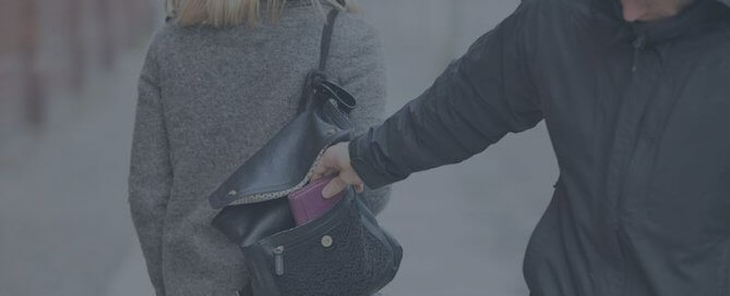 A man taking a woman's wallet from her pursue.