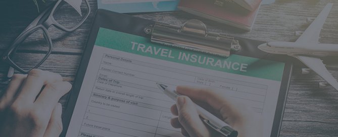 A clipboard with a travel insurance document on a desk