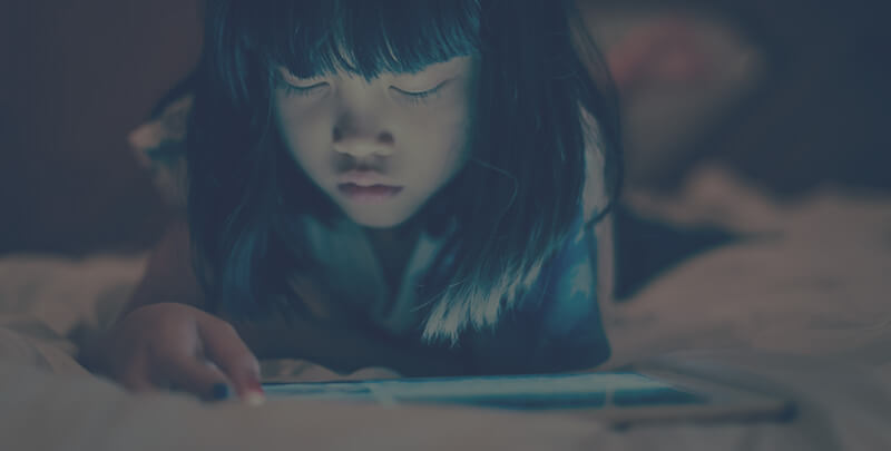 A young Asian girl using an tablet.