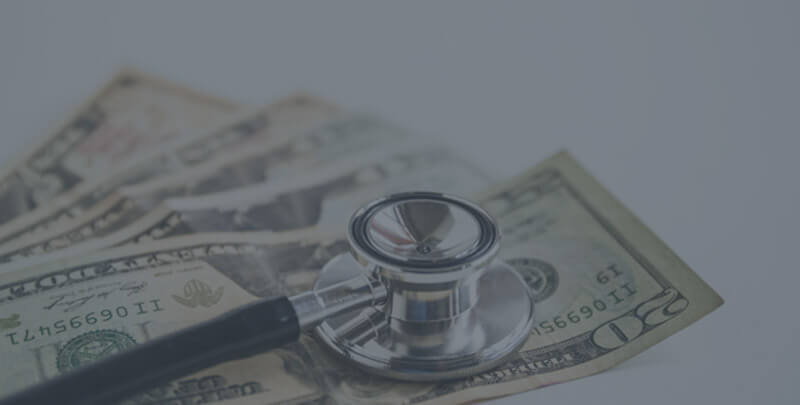 Cash on a white table with a stethoscope