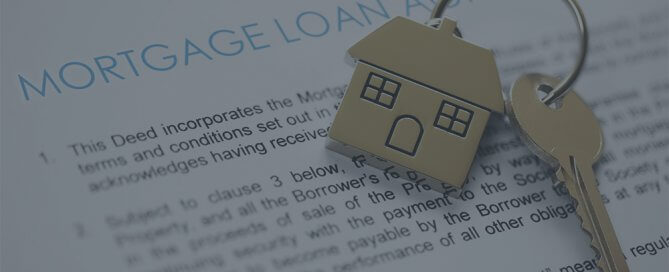 A mortgage loan paper with gold house keys.