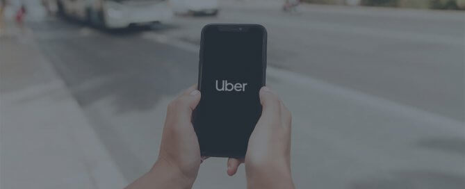 A person holding a phone with Uber on the screen.