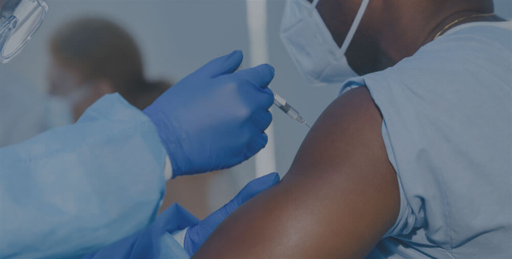 A medical professional giving a person a vaccine shot.