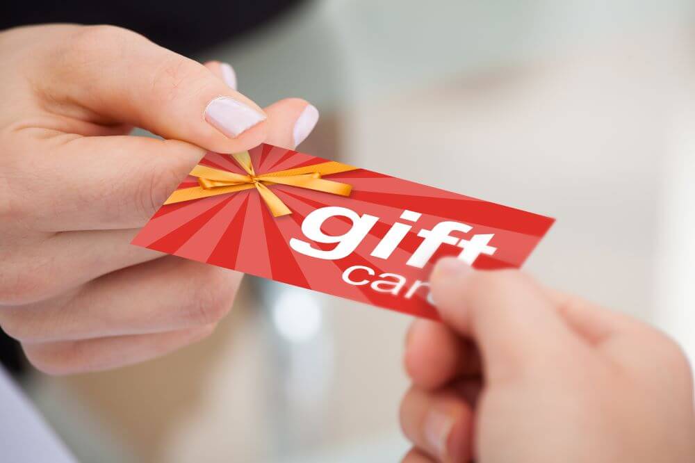 A person handing a gift card to someone.