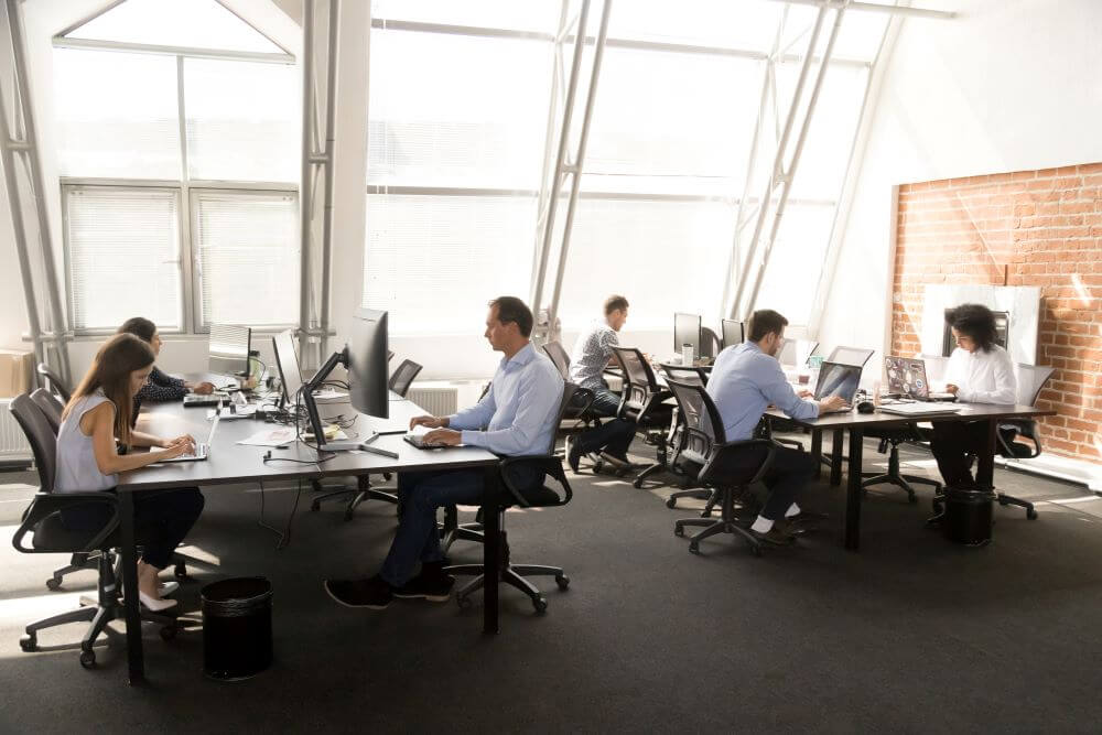 Workers sitting at desk in a big office space.