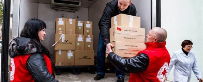 A person handing a boxes to another person in Ukraine