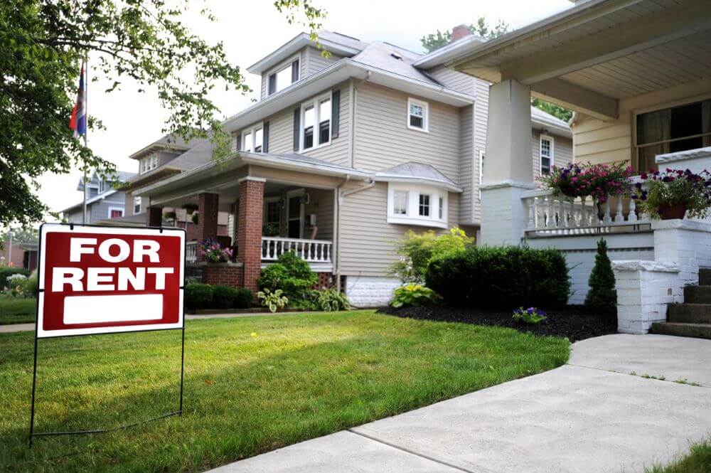 A house with a for rent sign.