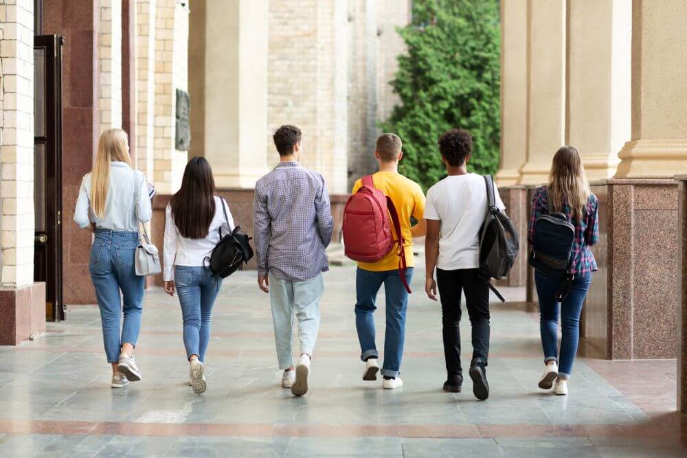 Group of students walking in college campus after classes