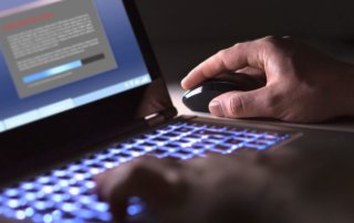 Man installing software in laptop in dark at night.