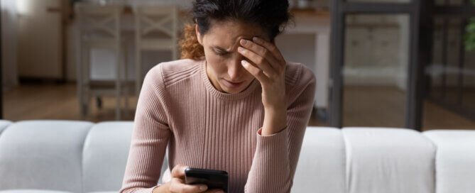 Unhappy woman use smartphone distressed with bad news