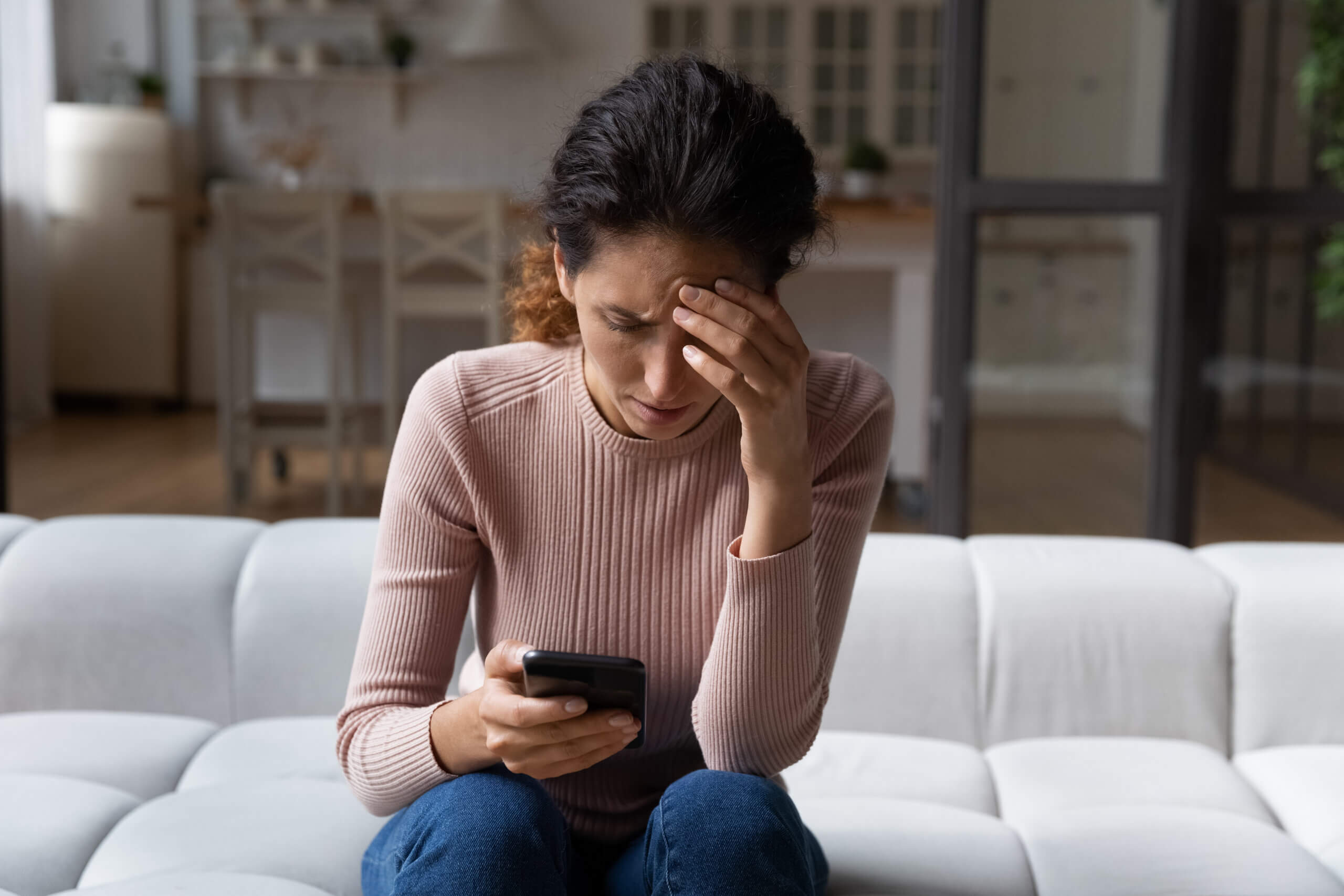 Unhappy woman use smartphone distressed with bad news