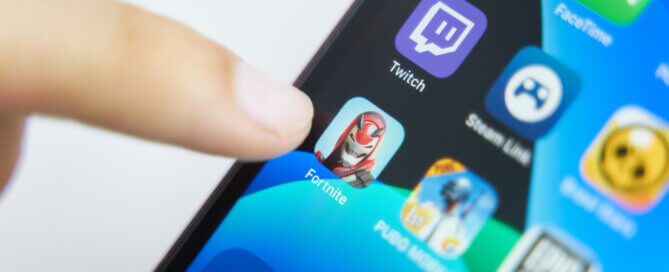 Finger pointing to Fortnite app on iPhone.