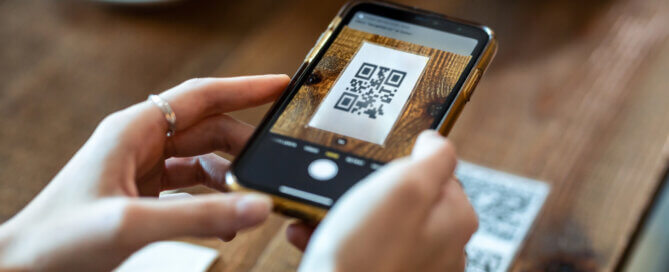 Close up of young woman hands using the smart phone to scan the qr code